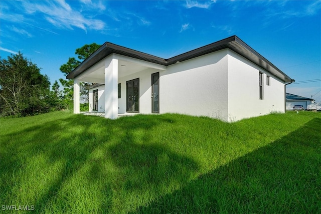 view of side of home with a lawn