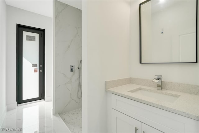 bathroom with vanity and a tile shower