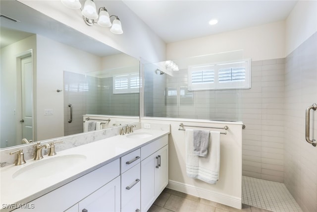 bathroom with tile patterned floors, a wealth of natural light, vanity, and a shower with shower door