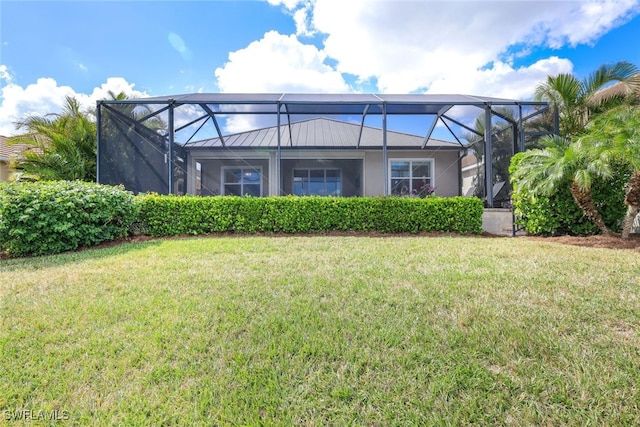 back of house featuring a lawn and glass enclosure