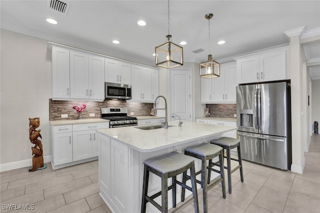 kitchen featuring appliances with stainless steel finishes, white cabinetry, a kitchen island with sink, and sink