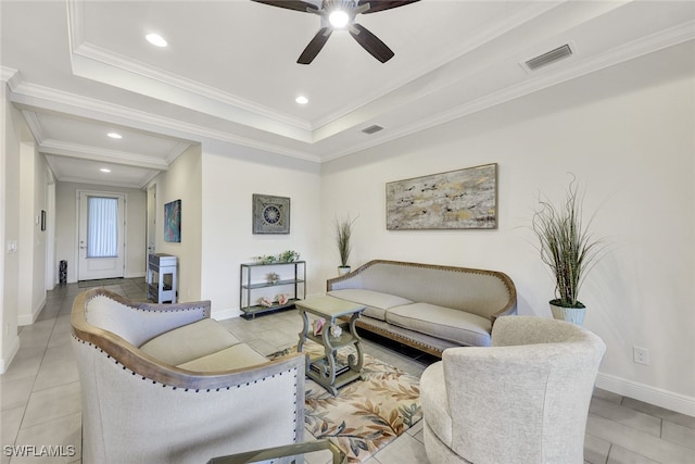 tiled living room with a tray ceiling, ceiling fan, and ornamental molding