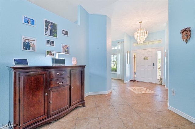 foyer featuring a notable chandelier, a healthy amount of sunlight, and light tile patterned floors