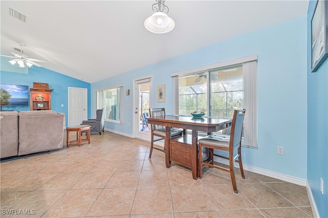 tiled dining room with ceiling fan and vaulted ceiling