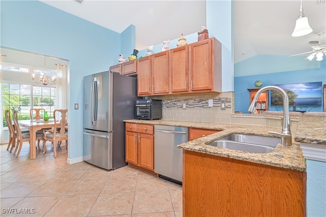 kitchen with decorative light fixtures, stainless steel appliances, sink, and backsplash