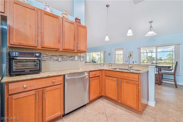 kitchen with tasteful backsplash, sink, dishwasher, hanging light fixtures, and light stone counters