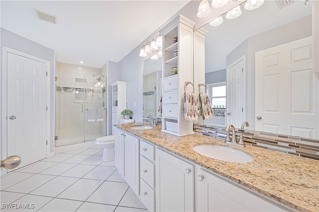 bathroom featuring toilet, tile patterned flooring, walk in shower, vanity, and tasteful backsplash