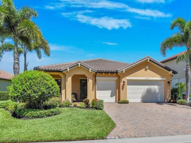 mediterranean / spanish-style home featuring a garage and a front lawn