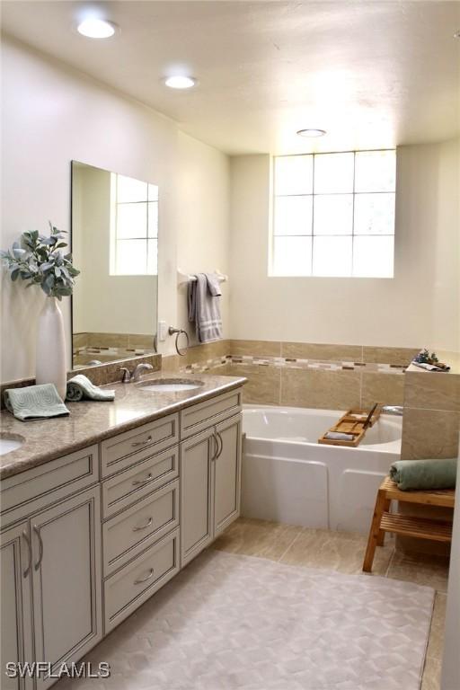 bathroom with vanity, a washtub, and tile patterned floors