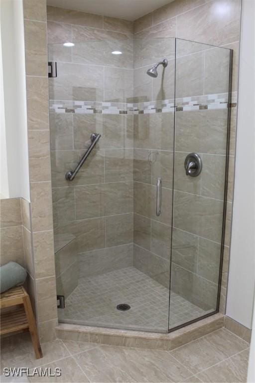 bathroom with tile patterned floors and a shower with shower door