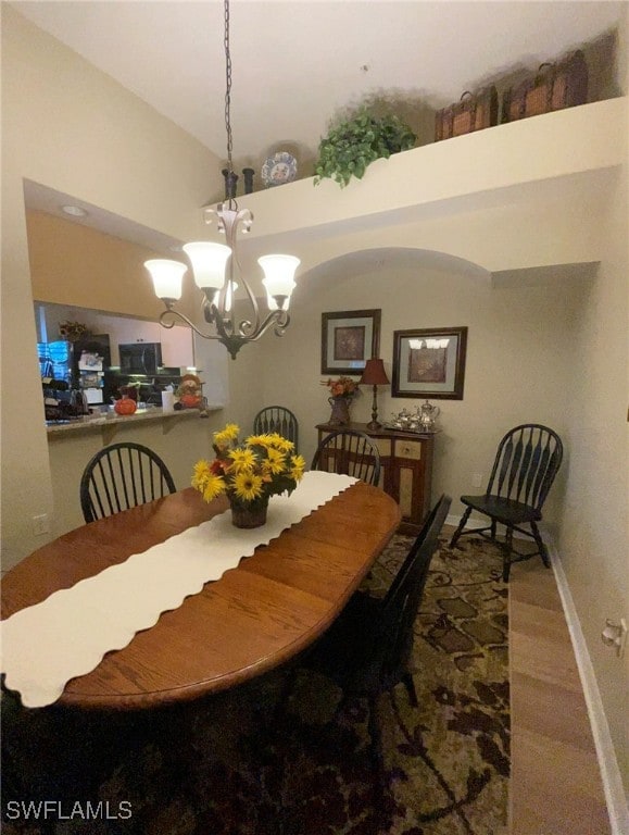 carpeted dining room featuring lofted ceiling and a chandelier