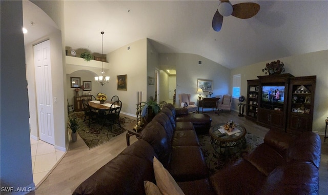 tiled living room with ceiling fan with notable chandelier and vaulted ceiling