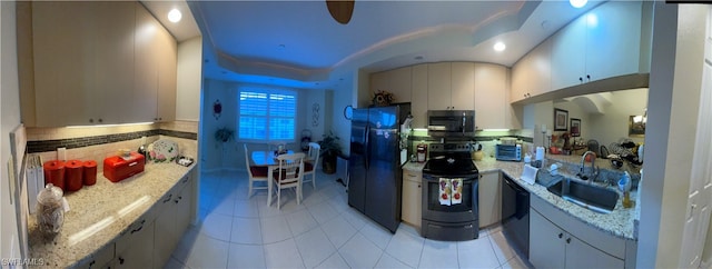 kitchen with sink, tasteful backsplash, light stone counters, light tile patterned floors, and black appliances