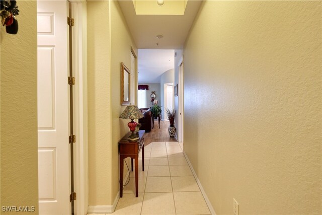 1105 Van Loon Commons Cir Unit 301, Cape Coral, FL 33909 - corridor with a textured wall, light tile patterned floors, and baseboards