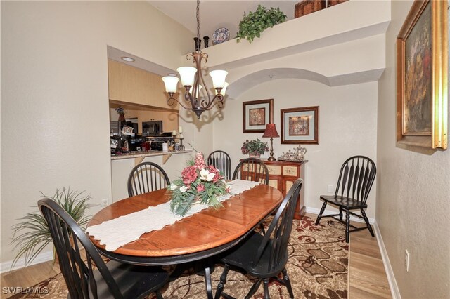 1105 Van Loon Commons Cir Unit 301, Cape Coral, FL 33909 - dining room with a chandelier, light wood-style floors, baseboards, and a textured wall