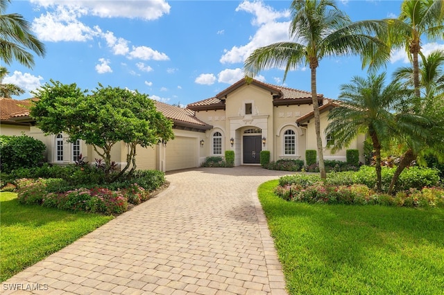 mediterranean / spanish-style house featuring a front lawn and a garage