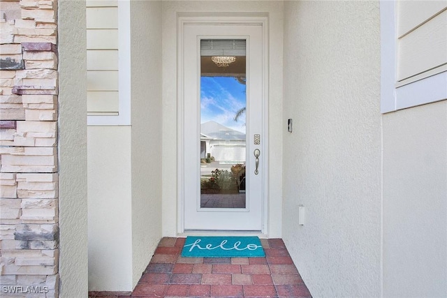 doorway to property featuring stucco siding