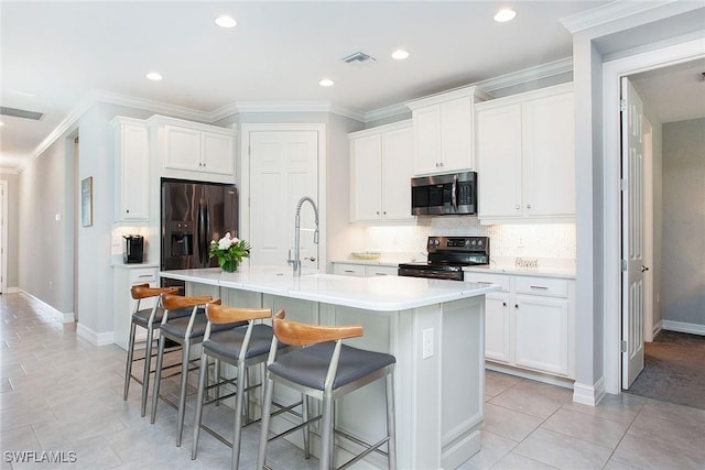 kitchen featuring visible vents, a sink, electric range oven, stainless steel microwave, and refrigerator with ice dispenser