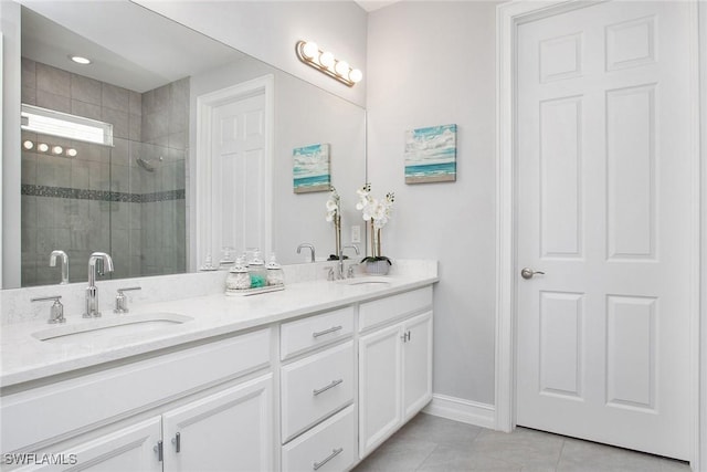 full bathroom with double vanity, tile patterned flooring, a shower stall, and a sink