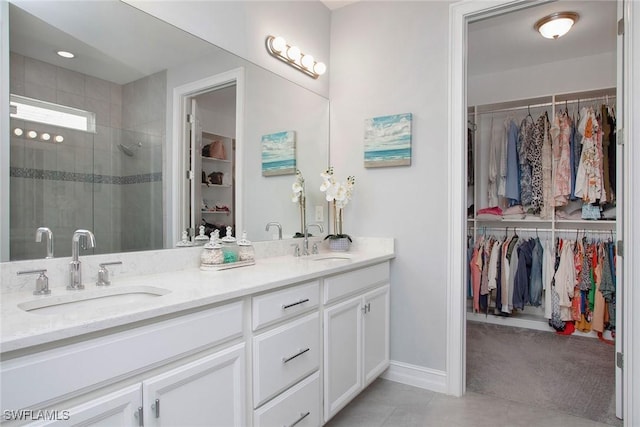 full bath with double vanity, a stall shower, a spacious closet, and a sink