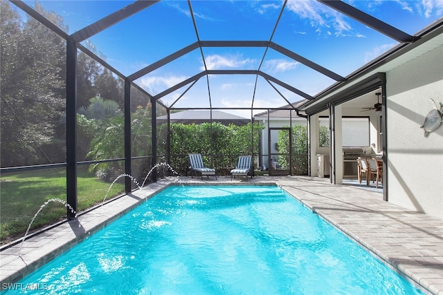 outdoor pool featuring glass enclosure and a patio