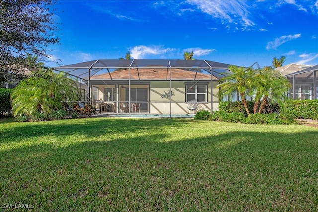 back of property featuring a lanai and a yard