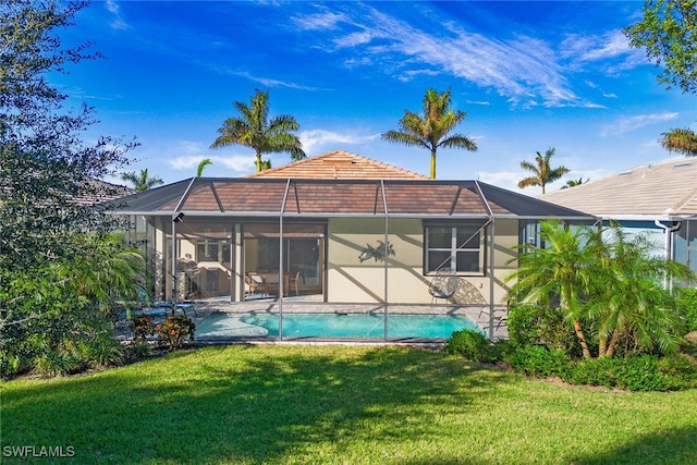 back of property with a lanai, a yard, a patio area, and an outdoor pool