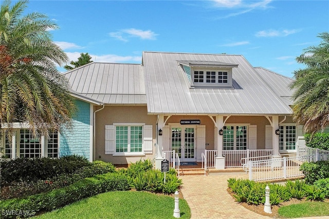 view of front of property with stucco siding, a porch, and metal roof