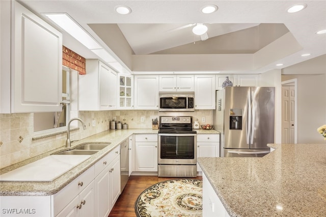 kitchen featuring lofted ceiling, sink, dark hardwood / wood-style flooring, white cabinetry, and stainless steel appliances