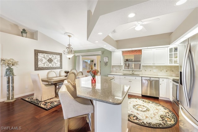 kitchen with decorative light fixtures, dark hardwood / wood-style flooring, white cabinetry, and stainless steel appliances