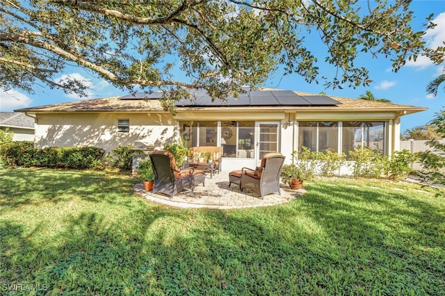 rear view of house featuring outdoor lounge area, solar panels, a sunroom, and a lawn