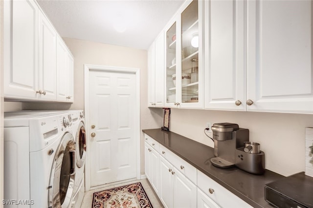 washroom with washing machine and clothes dryer and cabinets