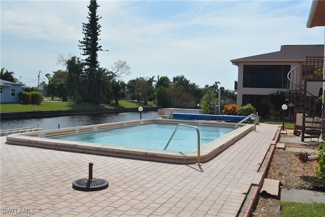 view of swimming pool with a water view, a patio area, and a sunroom