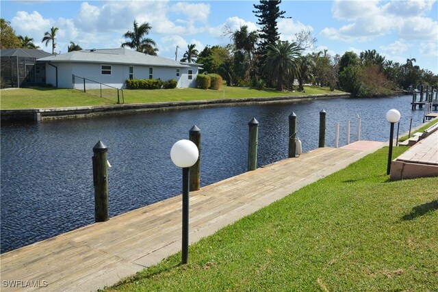 view of dock featuring a water view and a yard