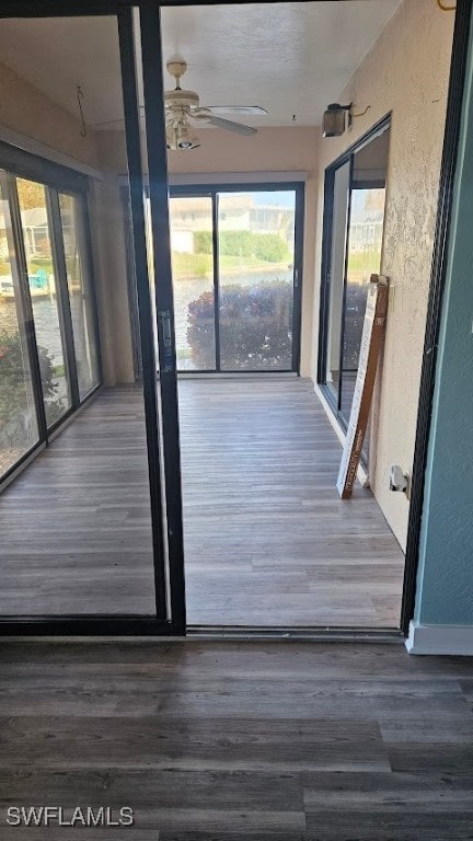 unfurnished sunroom featuring ceiling fan