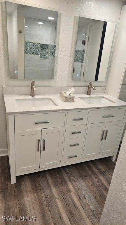 bathroom with a shower with door, hardwood / wood-style floors, and vanity