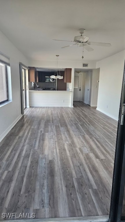 unfurnished living room with ceiling fan and hardwood / wood-style floors