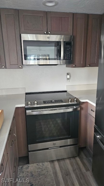 kitchen featuring appliances with stainless steel finishes and dark hardwood / wood-style floors