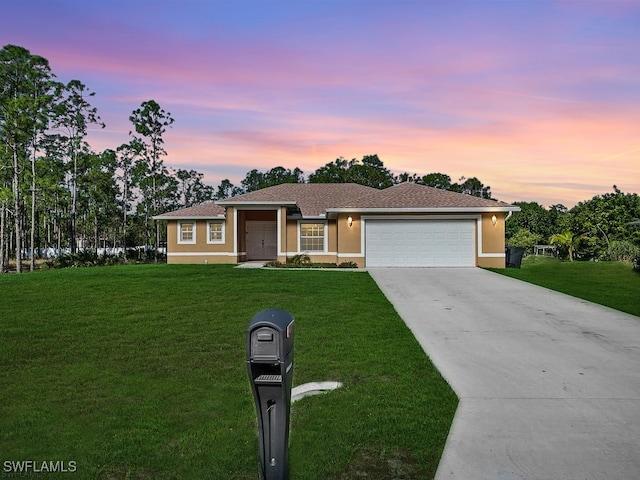 single story home featuring a garage and a lawn