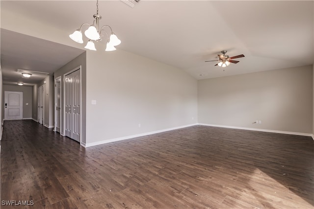 empty room with ceiling fan with notable chandelier, vaulted ceiling, and dark hardwood / wood-style floors