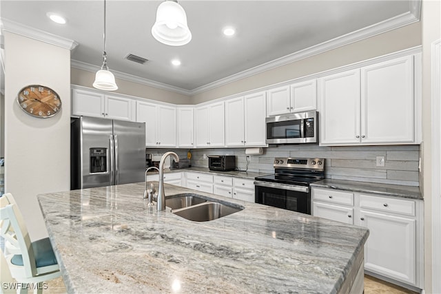 kitchen featuring decorative backsplash, sink, pendant lighting, white cabinetry, and appliances with stainless steel finishes