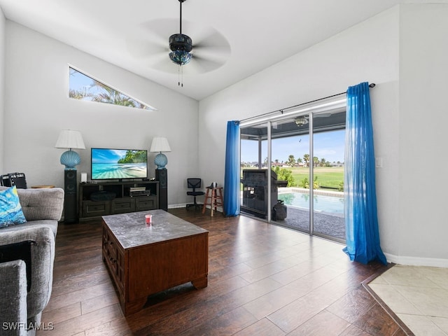 living room with ceiling fan, a healthy amount of sunlight, vaulted ceiling, and dark hardwood / wood-style flooring