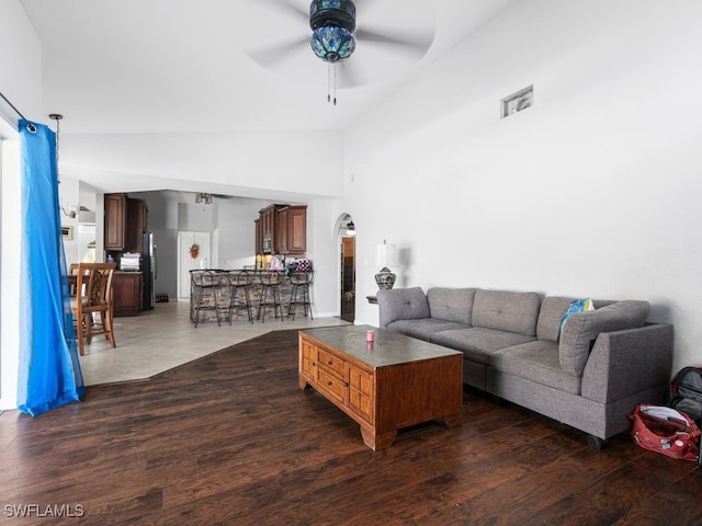 living room featuring dark wood-type flooring, high vaulted ceiling, and ceiling fan