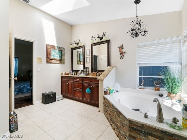 bathroom featuring vanity, a notable chandelier, tiled tub, and tile patterned floors