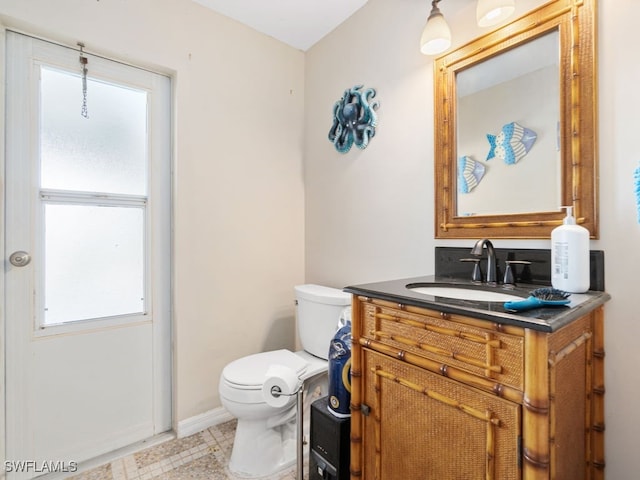 bathroom with vanity, toilet, and a wealth of natural light