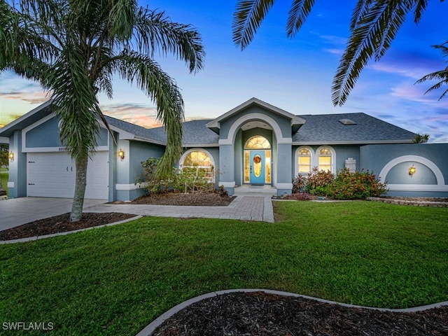 ranch-style house featuring a lawn and a garage