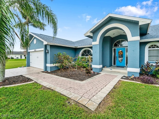 single story home featuring a front lawn and a garage