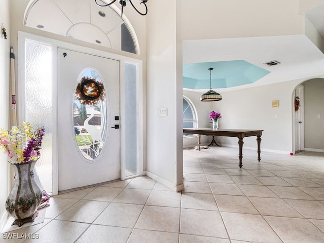 entrance foyer featuring light tile patterned flooring and a towering ceiling