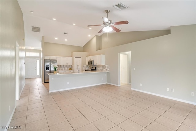 kitchen featuring appliances with stainless steel finishes, light tile patterned flooring, white cabinetry, ceiling fan, and high vaulted ceiling