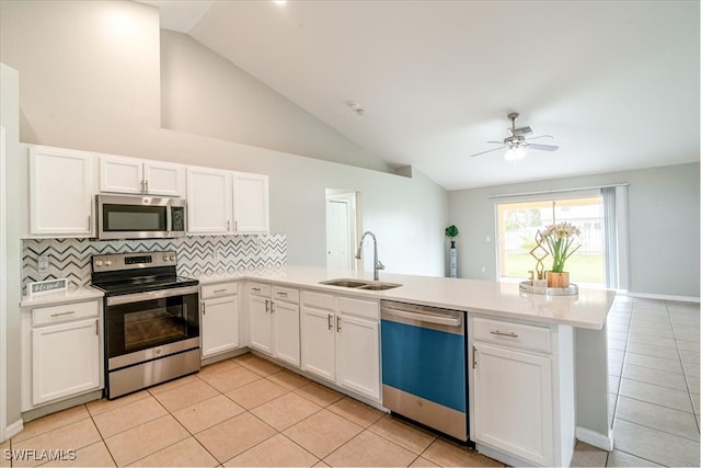 kitchen featuring appliances with stainless steel finishes, kitchen peninsula, white cabinets, and sink